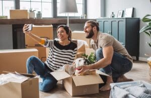 Couple Surrounded by Moving Boxes Buying New Home Easy Online Remote Closing Electronic Notary Signing