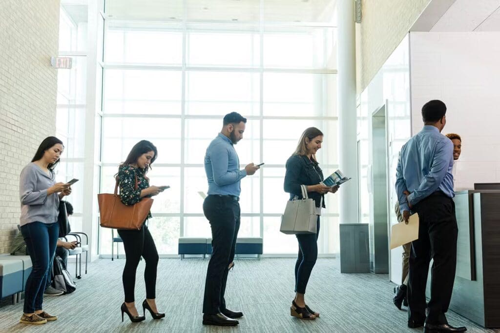 People Waiting In Line at Bank For A Notary Public To Sign